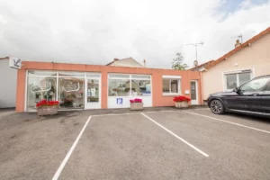 Façade de la boutique de pompes funèbres Funéplus avec vitrine et parking.