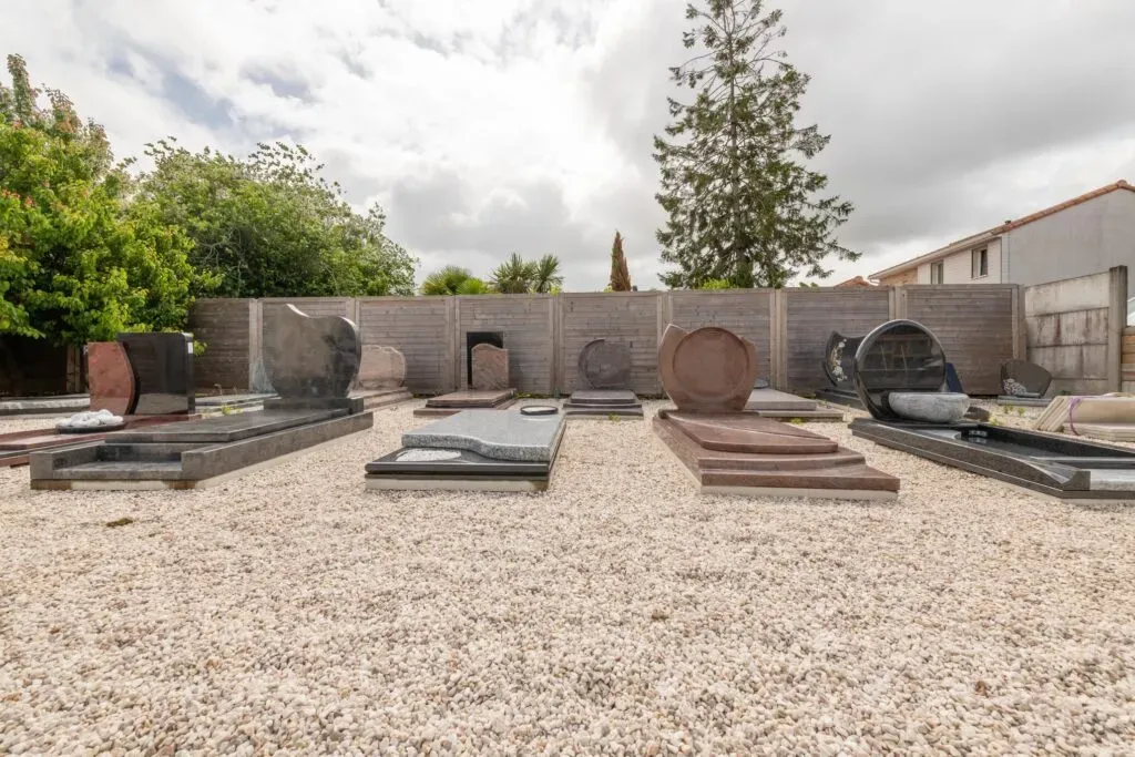 Exposition extérieure de monuments funéraires en granit de différentes couleurs.